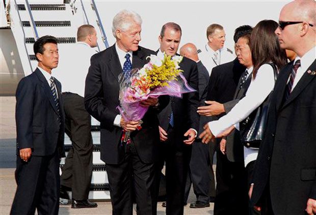 Clinton receives flowers before departing North Korea